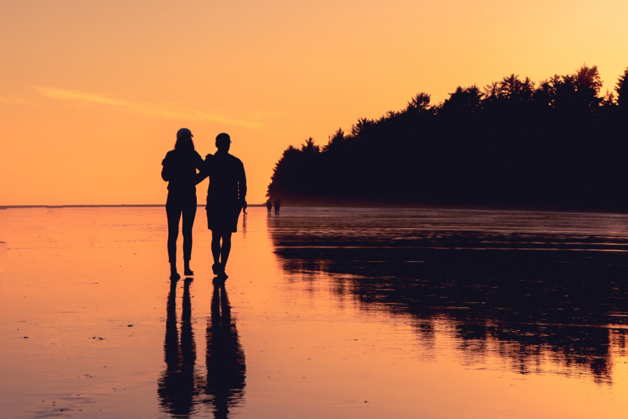 homem e mulher a caminhar numa praia